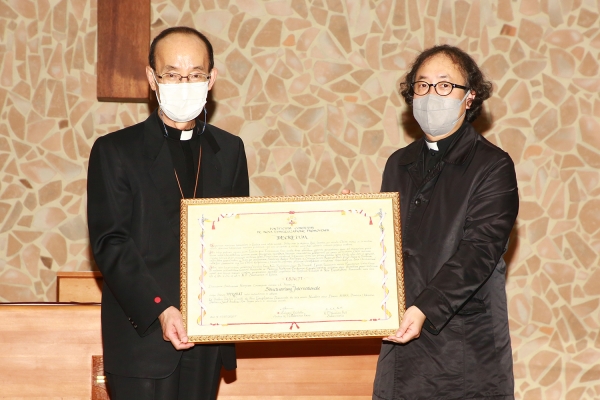 김종수 천주교대전교구장이 15일 해미국제성지에서 한광석 해미국제성지 전담신부에게 교황청 승인 국제성지 교령을 전달하는 모습