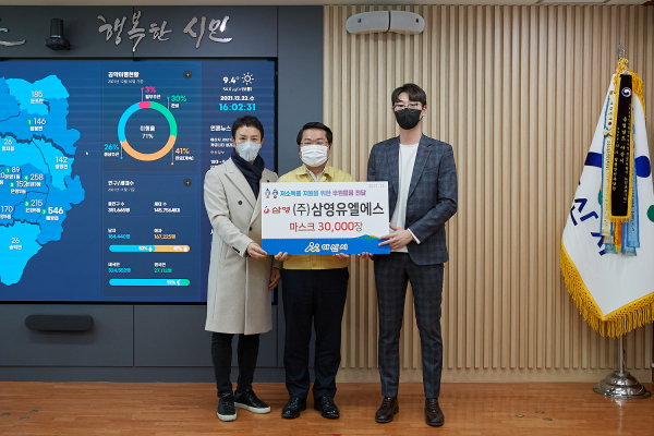 오세현 아산시장과 삼영유엘에스 관계자들이 후원물품 전달 후 기념 촬영 장면을 찍고 있다