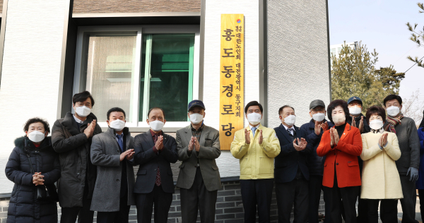 황인호 동구청장을 비롯한 내빈들이 홍도동경로당 현판 앞에서 기념촬영을 하고 있다.