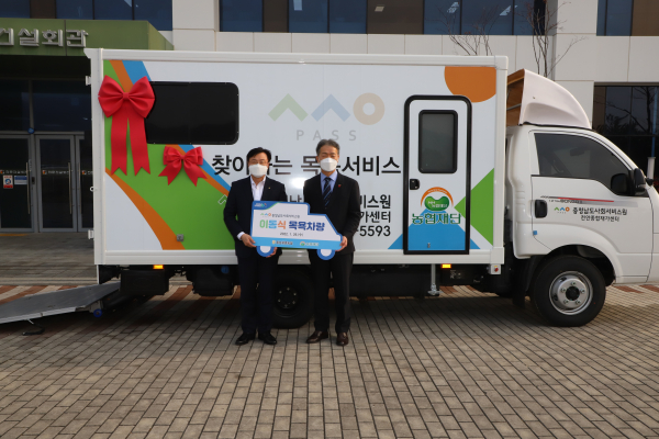 이종욱 충남세종농협본부장(왼쪽)이 조경훈 충청남도사회서비스원장(오른쪽)에게 이동식 목욕차량을 전달하고 있다.