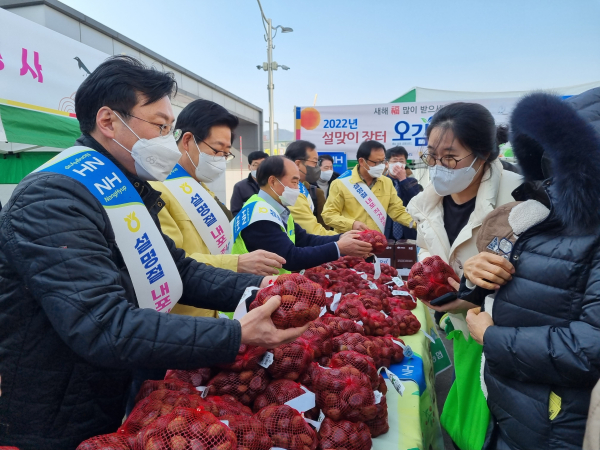 양승조 충남도지사(왼쪽 뒤)와 이종욱 충남세종농협본부장(왼쪽 앞)이 설명절 내포직거래 장터를 찾은 도민들에게 공주밤을 나누어 주고 있다.