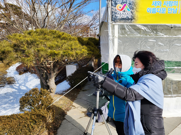 자연환경 해설사가 8일 철새 탐조대 이용시민에게 철새를 설명하는 모습