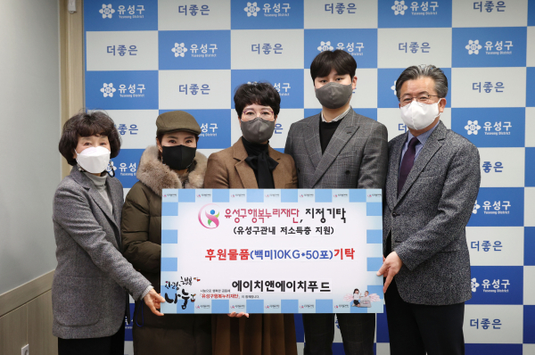 15일 행복사랑방에서 에이치앤에이치푸드가 정용래 유성구청장(오른쪽)과 김홍혜 유성구행복누리재단 이사장(왼쪽)에게 백미 500kg을 기탁하고 있다.