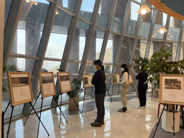 오는 5월까지 산림치유원 일원에서 산림과 인문학의 만남 '인성의 향, 디카시' 전시회를  열고 있는 가운데 방문객들이 전시 작품을 관람하고 있다