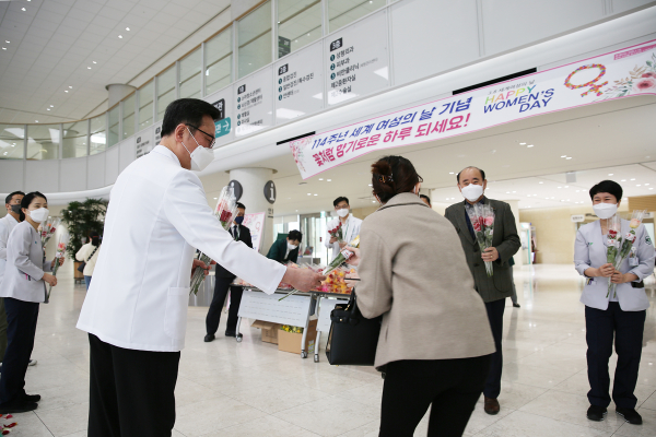 배장호 의료원장이 내원객에게 꽃을 선물하는 모습