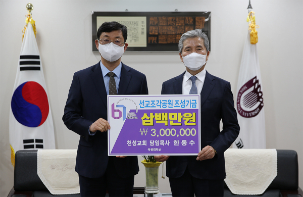 총장실에서 천성교회 한동수 담임목사(왼쪽)가 권혁대 총장에게 선교조각공원 조성기금을 전달하며 기념촬영