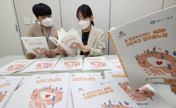 동구청 직원들이 사회복지업무 매뉴얼 책자를 살펴보고 있다.