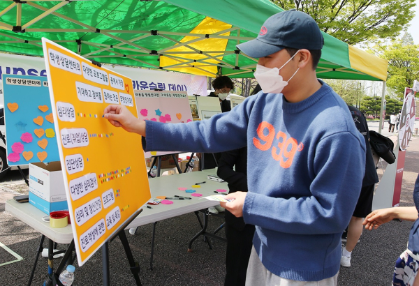 목원대학교 학생회관 앞에 차려진 카운슬링 데이 홍보 천막에서 학생들이 설문 등에 참여하고 있다.