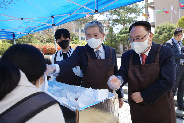 20일 정오 목원대 중앙도서관 앞 광장에서 유영완 학교법인 감리교학원 이사장(오른쪽), 권혁대 총장(가운데), 장자영 총학생회장이 학생들에게 크로플을 전달하고 있다.