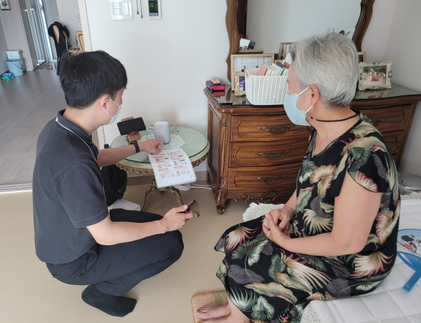 돌봄서비스 대상자에게 인공지능(AI)스피커를 설치 후 사용법을 설명하고 있다