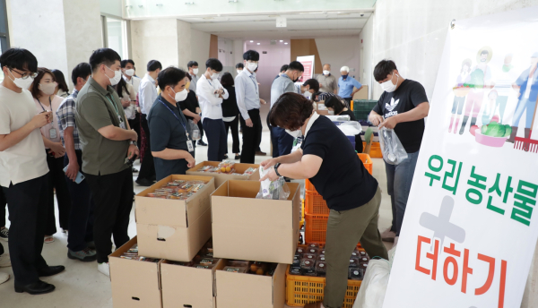 22일 열린 농산물 사주기 캠페인에서 플럼코트와 블루베리를 구매하기 위해 줄을 서고 있다