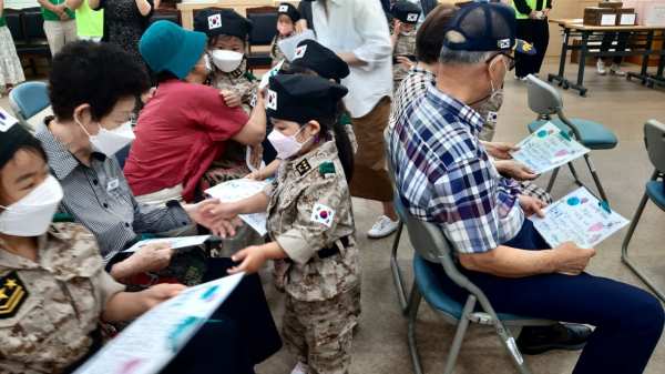 행사에 참석한 산내동 아이들이 보훈대상자 어르신들에게 감사편지를 전달하고 있다.