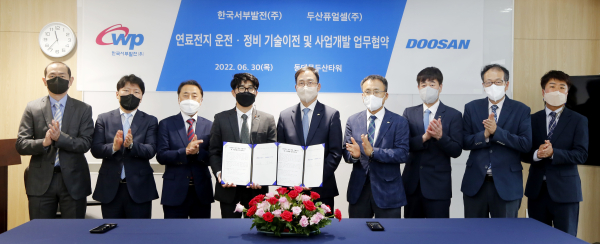 김성균 서부발전 성장사업본부 부사장(가운데)과 제후석 두산퓨얼셀 부사장(왼쪽 네 번째), 양측 관계자들이 업무협약 후 기념촬영에 응하고 있다.