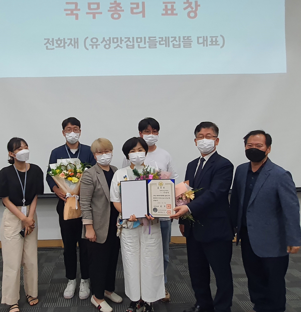 지난 8일 개최된 제4회 사회적경제 통합박람회 자활기업 정책포럼 행사에서 유성맛집 민들레집뜰 대표와 대전유성지역자활센터 직원들이 기념촬영 하고 있다