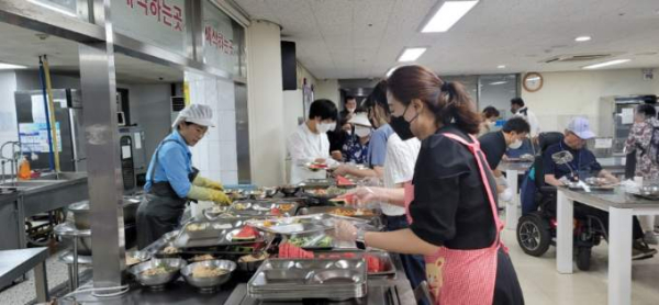 지난 15일 유성구 장애인종합복지관에서 봉사자들이 삼계탕 배식을  하고 있다.