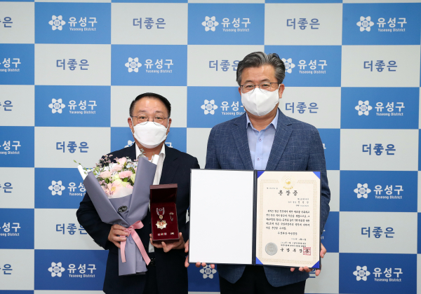 21일 구청 행복사랑방에서 정용래 유성구청장(오른쪽)이 6.25 참전 유공자 유가족에게 화랑무공훈장을 전수 후 기념촬영