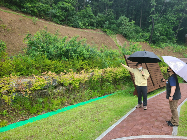 최재성(좌측) 한국산림복지진흥원 부원장이 13일 국립제천치유의숲(충북 제천시 청풍면)에서 사면 안정화 상태를 점검하며 직원과 이야기를 나누고 있다.