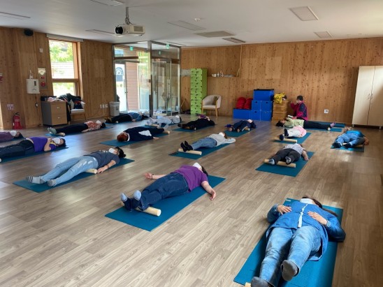 산림치유원 문필마을 배움방에서 고객들이 '통나무 건강마사지'를 하고 있다.