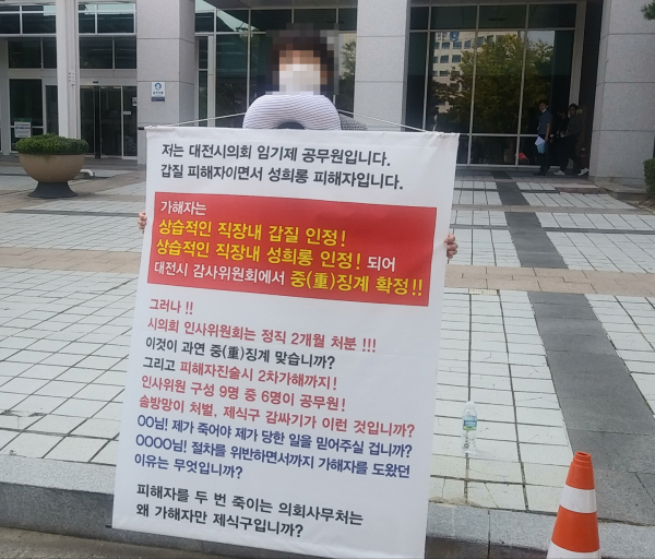 성희롱·갑질 피해자인 대전시의회 사무처 소속 공무원이 30일 시의회 앞에서 가해자의 낮은 수준의 징계를 비판하며 1인 시위를 벌이고 있다.