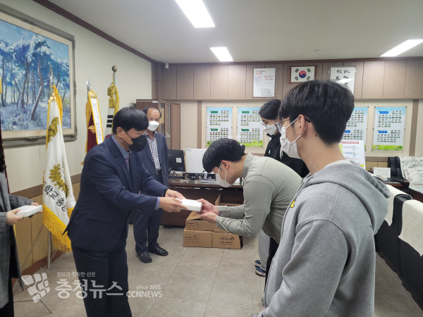 유재중 회장이 학생들에게 수능 기원 떡을 전달하고 있다.