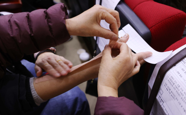 교육 참석자들이 테이핑 요법 실습을 하고 있다.