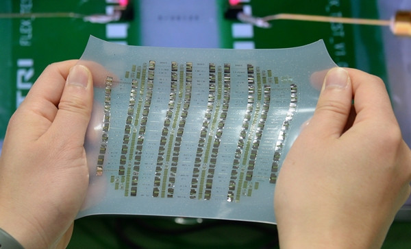 ETRI 연구진이 유연(스트레처블) 소재 위에 집적된 신축성 반도체 소자 어레이를 잡아당기는 모습