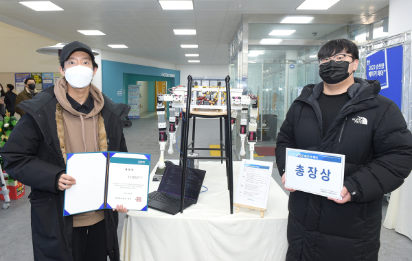‘2022 메이커 페어’ 행사에서 총장상을 수상한 스마트모빌리티공학과 2학년 한도현(사진 오른쪽), 손태일(사진 왼쪽) 학생팀이 출품작과 함께 기념촬영