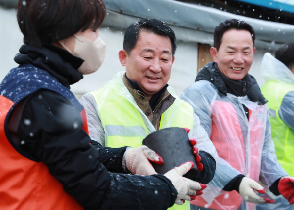 서철모 서구청장과 ㈜두드림 이철희 대표가 함께 연탄을 전달하고 있다.