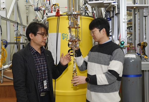 KRISS 배명호(왼쪽), 김범규 책임연구원이 단일 전자원 소자를 극저온 냉동기에 설치하고 있다.