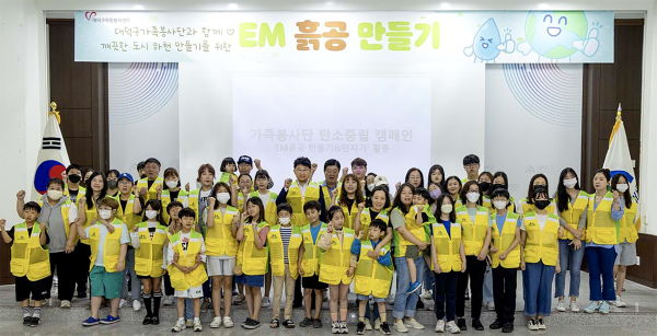 최충규 이사장(사진 두 번째 줄 가운데)과 가족봉사단원들이 지난 20일 대덕구청 청렴관에서 도시하천을 살리기 위한 EM흙공을 만든 후 기념촬영