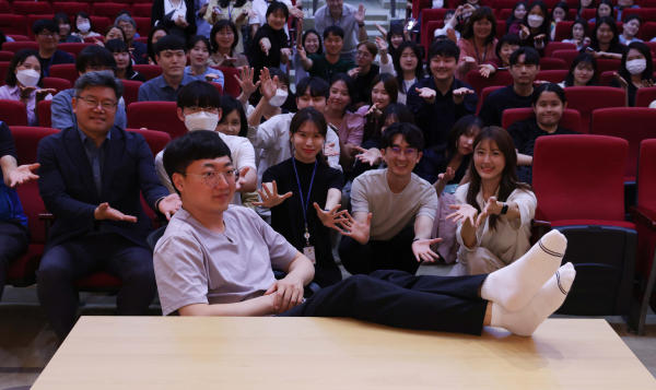 ‘충주시 홍보맨’ 김선태 주무관이 동구청 직원들에게 둘러싸여 시그니처 포즈를 취하고 있다.