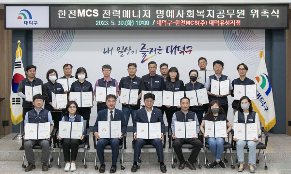 최충규 대덕구청장(사진 첫 번째 줄 가운데)이 30일 구청에서 명예사회복지공무원으로 위촉된 한전MCS(주)대덕유성지점 검침원들과 위촉장을 들고 기념 촬영