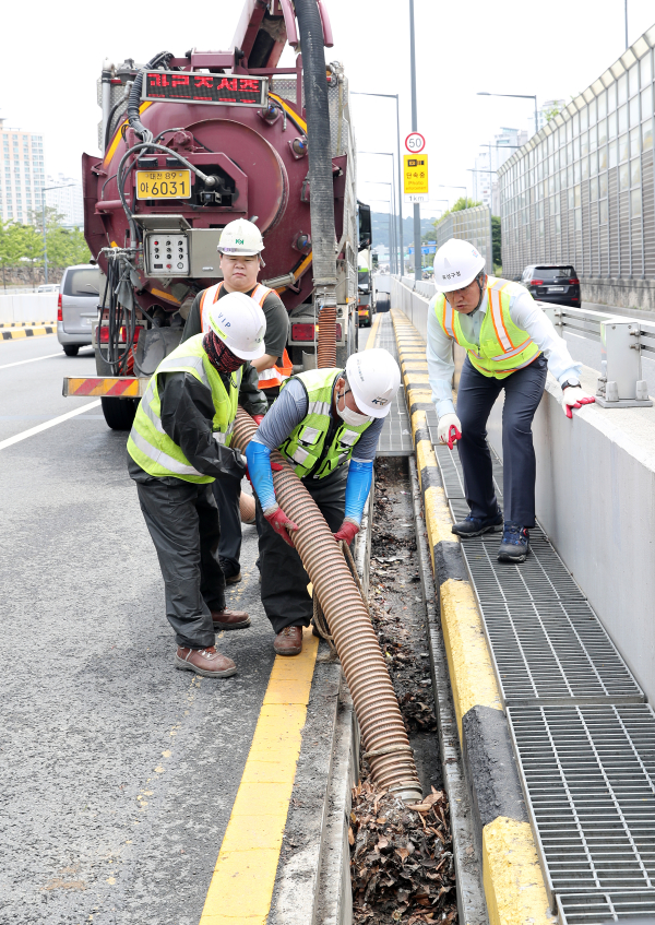 정용래 유성구청장(오른쪽)이 여름철을 맞아 하수도 준설작업에 참여하고 있다.