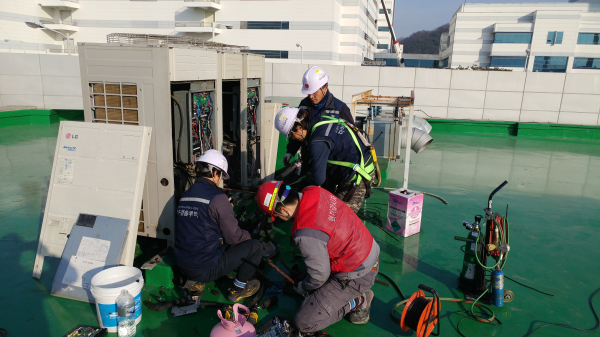 냉난방기 수리 전문업체 엔지니어가 실외기를 수리하고 있다.