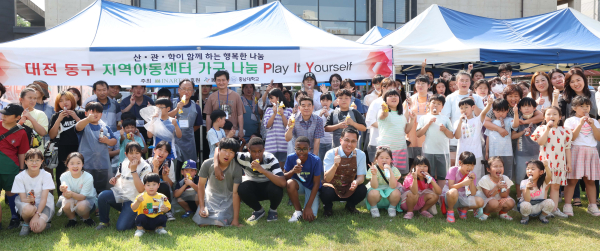 ㈜인아트‧대전 동구‧충남대 관계자들과 지역아동센터 이용 아동들이 함께 원목가구 만들기 등 체험 후 기념사진