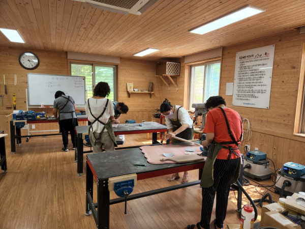 대청목재문화체험장의 목공체험 프로그램을 신청한 구민들이 도마를 만들고 있다.