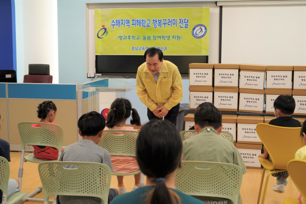 김지철 교육감은 24일 청양 청남초등학교에 방문하여 수해피해 지역 방과후·돌봄 참여학생들에게 행복꾸러미를 전달하며 인사하고 있다