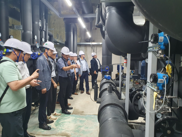 K-water연구원 조용 박사(사진의 가운데)가 8월 31일 진행된 수열산업 기술워크숍 참석자들에게 한강유역본부 내 설치된 500RT급 대용량 히트펌프 실증플랜트 시설 현황을 브리핑 모습