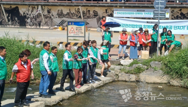 한국건강관리협회 대전충남지부 임직원과 대전동구새마을회 회원들이 동구 인동 대전천에서 EM흙공 던지기 캠페인을 하고 있다.