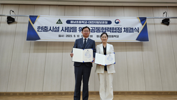 강만희 대전지방보훈청장(좌)과 문혜령 용남초등학교 교장(우)이 협약서를 들고 있다
