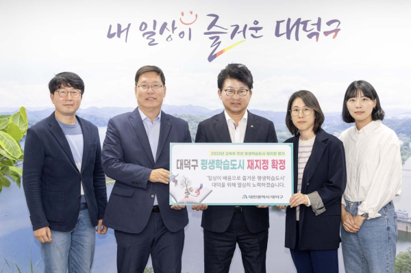 최충규 대덕구청장(사진 가운데)와 직원들이 17일 교육부 주관 대덕구 평생학습도시 재지정 확정을 축하하는 폼보드를 들고 기념촬영