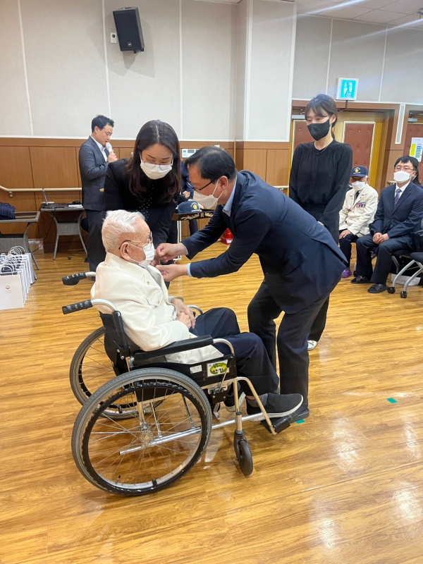 강만희 대전지방보훈청장이 보훈요양원에 입소한 6‧25참전유공자에게 뱃지를 달아드리고 있다