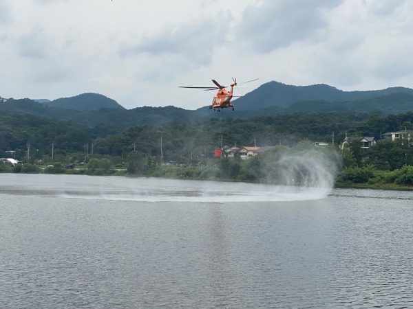 강원도 횡성 반곡저수지에서 소방헬기가 소방 용수를 담고 있는 모습