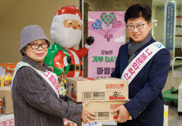 최충규 대덕구청장(사진 오른쪽)이 18일 구청에서 열린 ‘기부식품 나눔의 날’ 행사에 참석해 어려운 이웃들을 위한 식료품을 전달하고 있다.