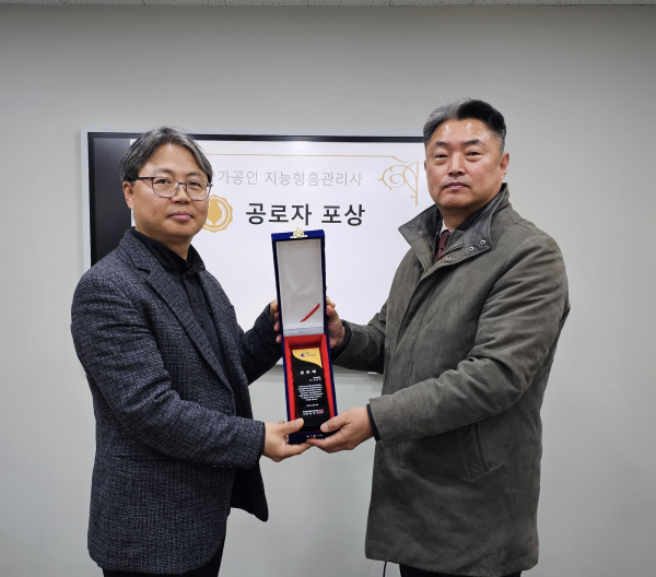 지난 18일 한국정보통신자격협회 사무국 공성우 사무국장(오른쪽)이 대덕대학교 김일진교수(왼쪽)에게 공로패를 전달하고 있다.