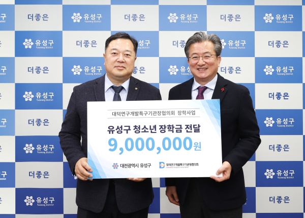 지난 26일 행복사랑방에서 김장성 회장(왼쪽)가 정용래 유성구청장(오른쪽)에게 장학금을 기탁하고 있다.