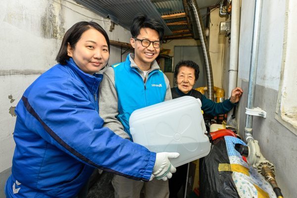 KT&G복지재단 관계자들이 서울 용산구의 한 가정을 방문해 난방연료를 지급하고 있는 모습