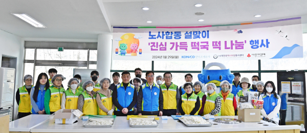 한국조폐공사 임직원과 자원봉사자들이 떡국 떡 썰기 봉사활동 후 기념촬영을 하고 있다