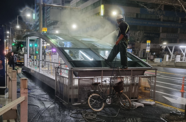 역사 출입구 캐노피에 겨우내 쌓인 퇴적물과 미세먼지를 제거중이다.