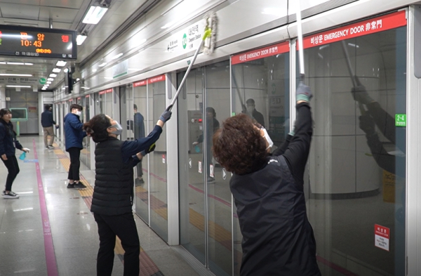 스크린도어를 청소 중인 대전교통공사 직원들